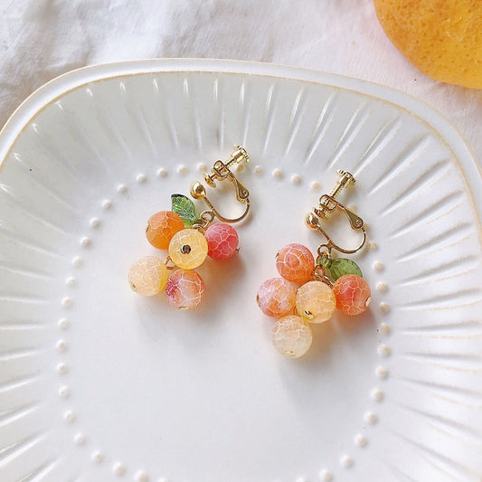 A bunch of orange fruit earrings