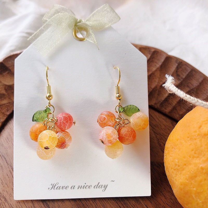 A bunch of orange fruit earrings